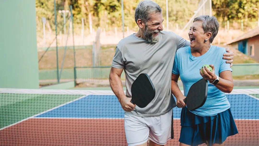 middle age couple playing pickleball