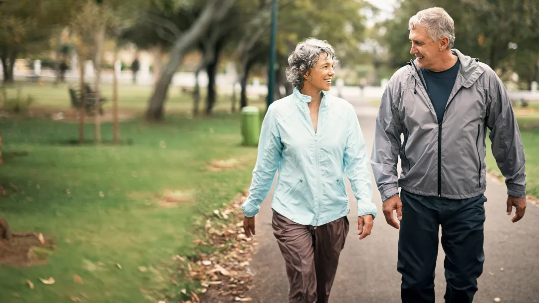 a middle-aged couple walking in a park