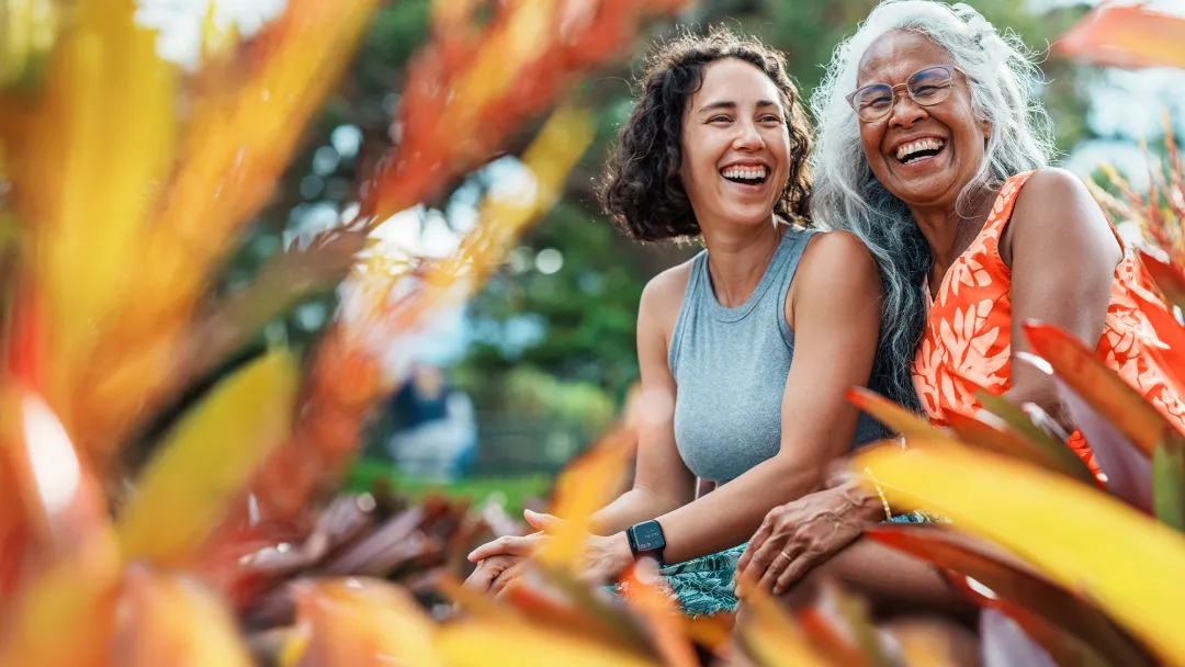 mom and daughter smiling in a garden