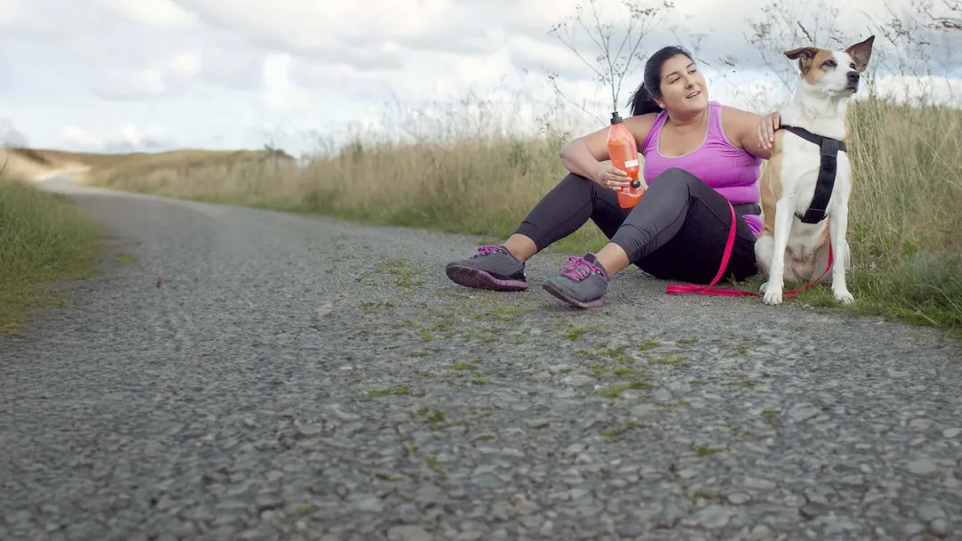 Woman with a dog taking a break from exercising outdoors