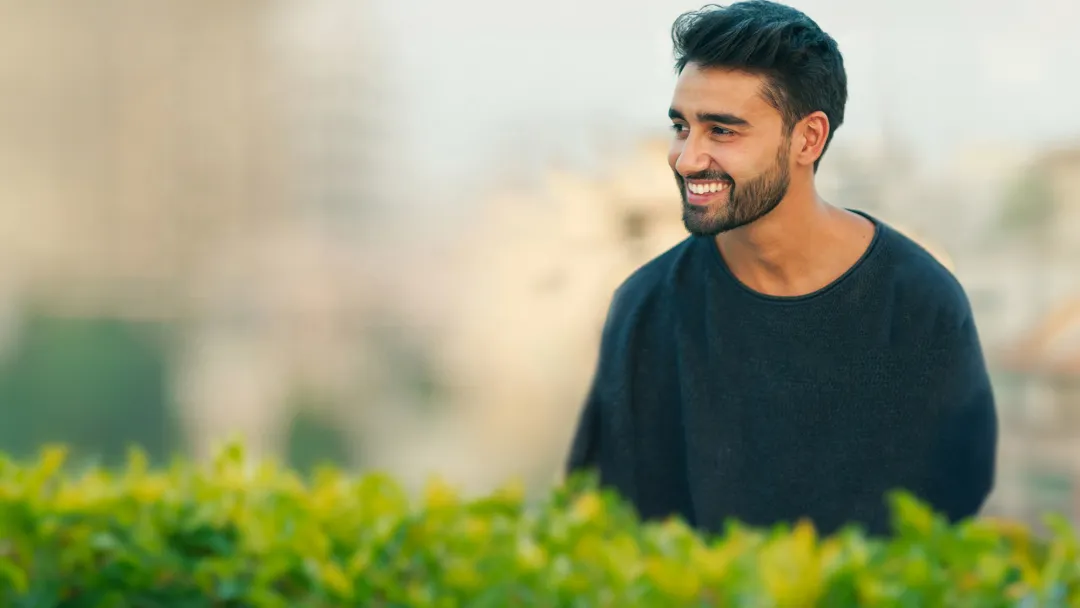 man outdoors smiling looking away