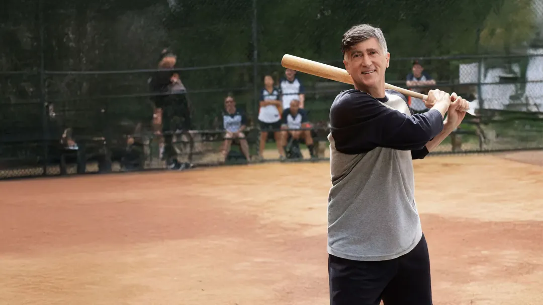 older man with a bat playing baseball