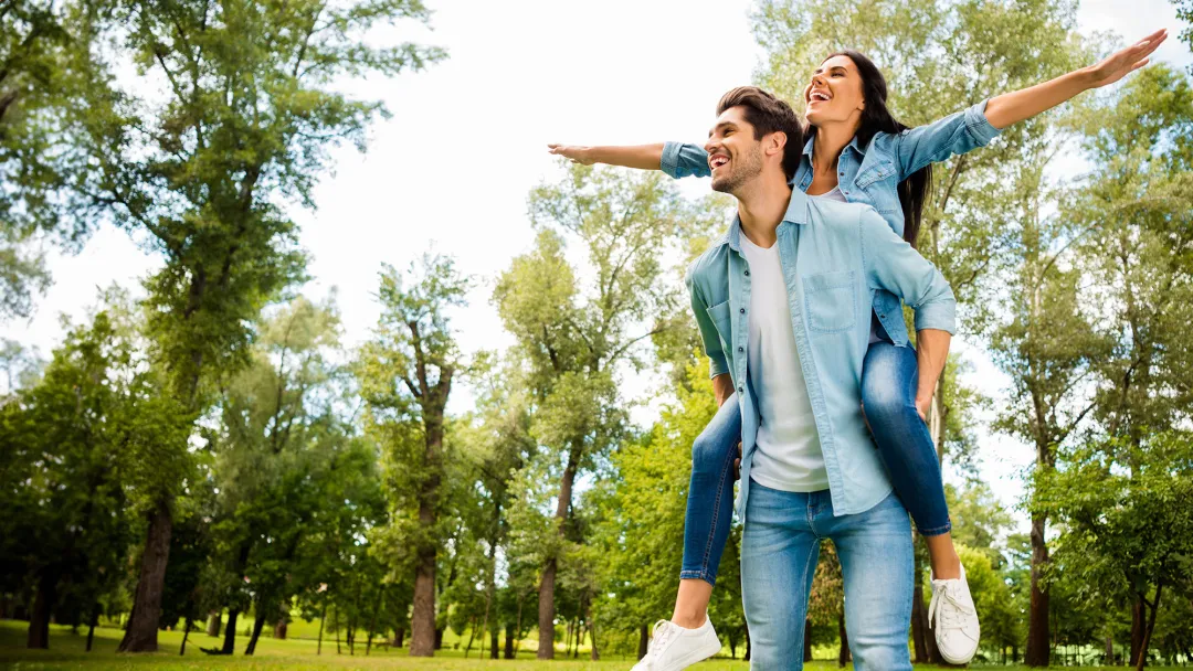 couple woman on mans shoulders outdoors