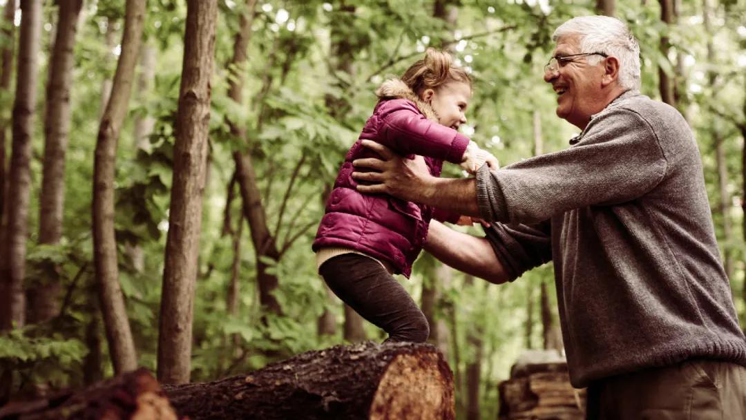 a grandpa picking up his granddaughter