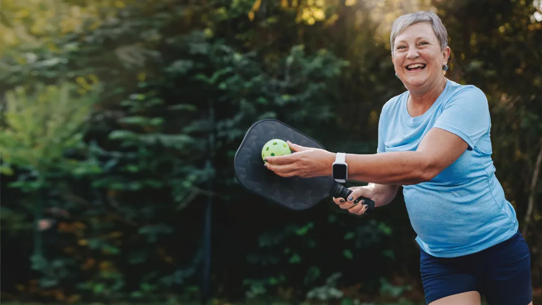 Woman playing pickleball outdoors