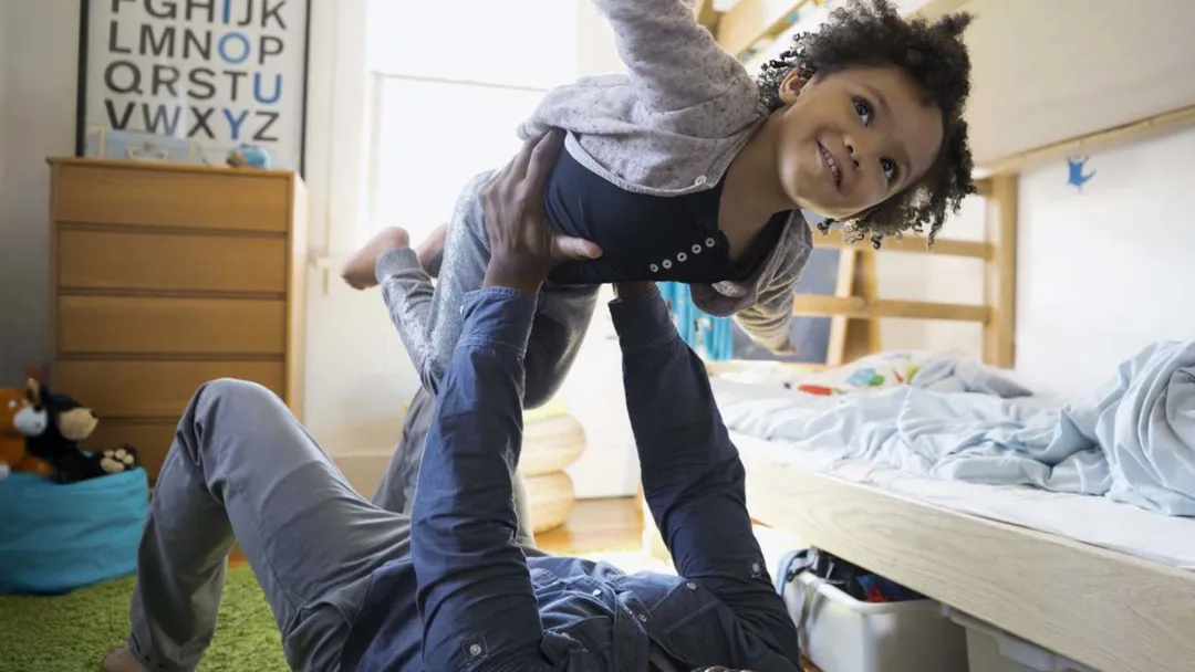 Father playing airplane and lifting his daughter up