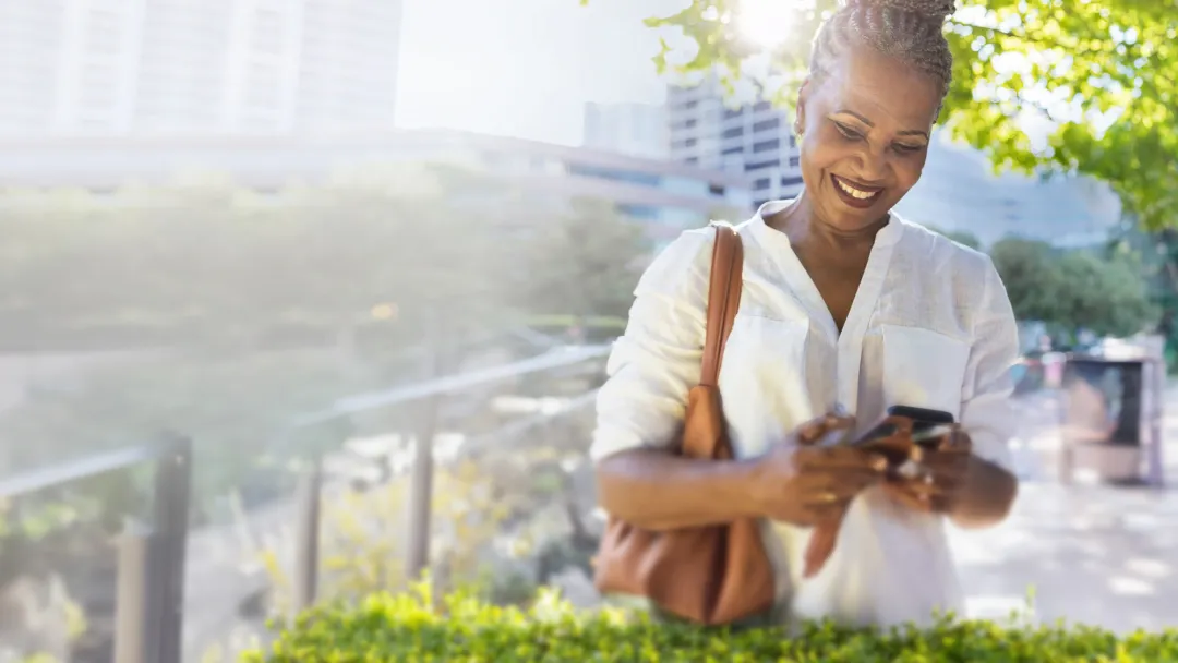 woman outdoors checking her mobile phone