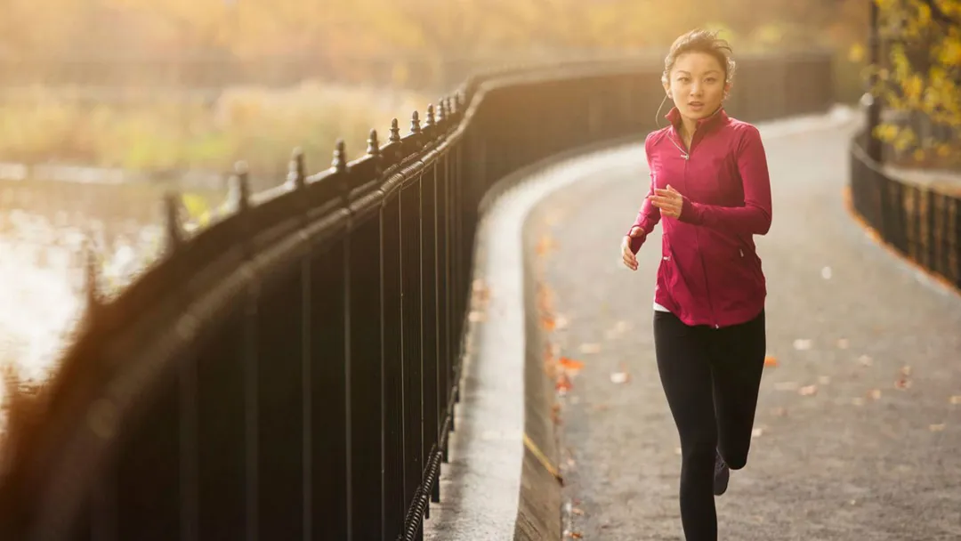 woman running on a path next to a lake