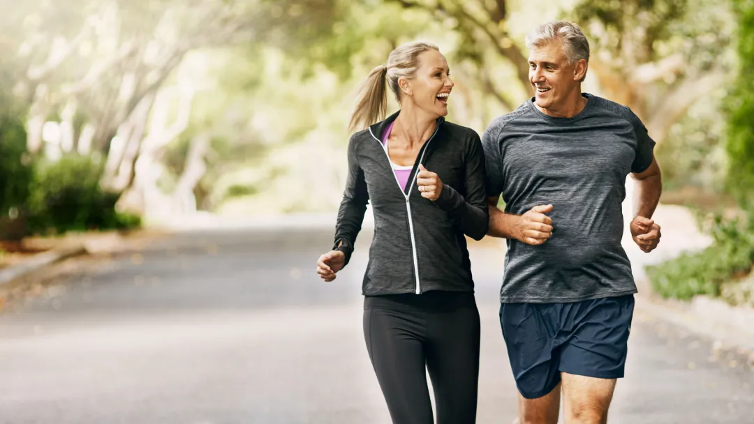 a mature couple jogging and smiling