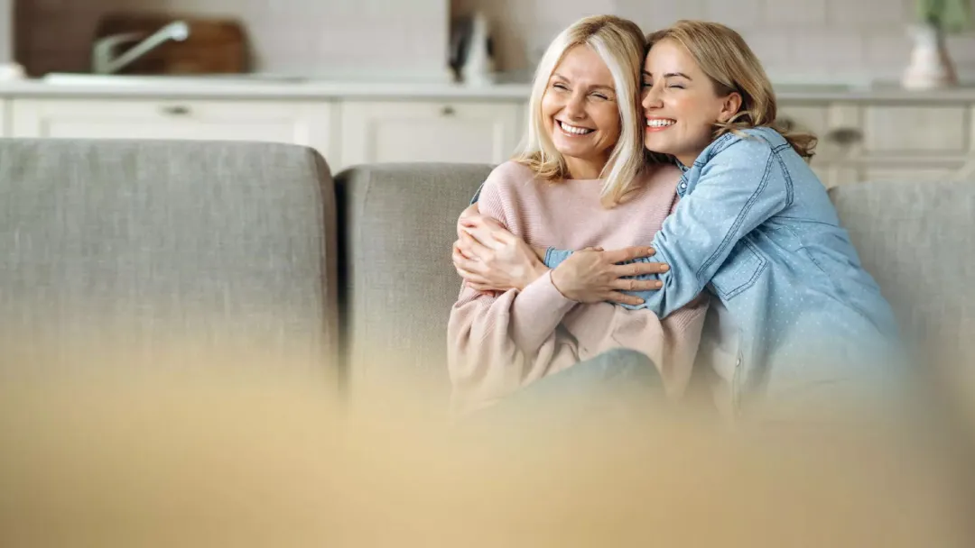 Mother and daughter sitting on couch