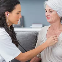 A Provider Checks Her Patient's Heart Beat with a Stethoscope. 