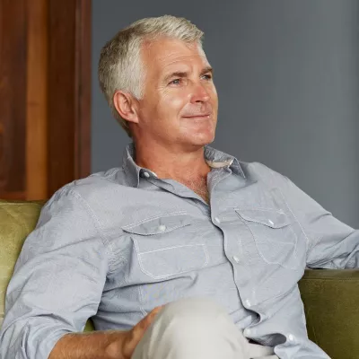 A man at home sitting on his sofa.