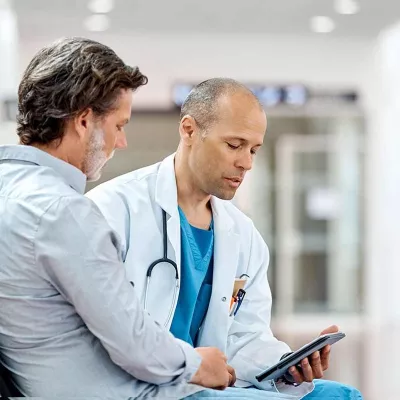 Male doctor talking to man with beard