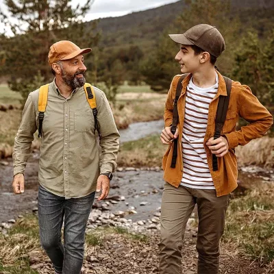 Father and son walking outdoors with backpacks