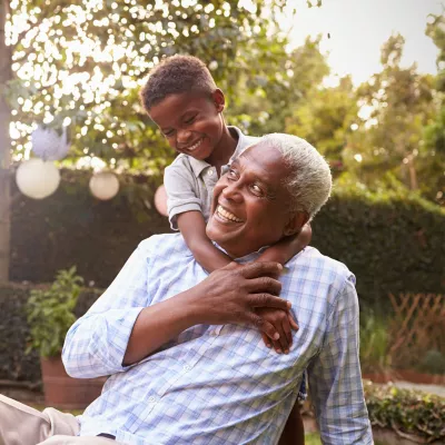 grandpa and grandson laughing outdoors