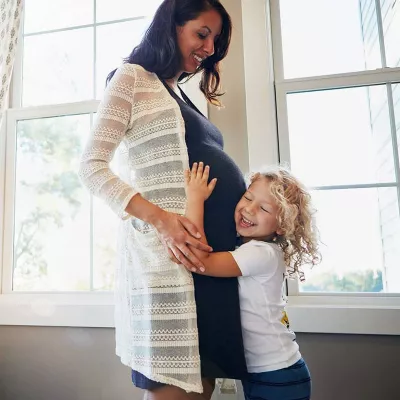 pregnant-mother-with-daughter-hugging