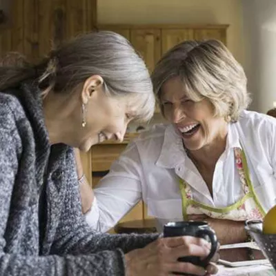 two-women-seating-and-laughing