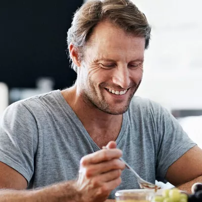 man-eating-and-smiling-at-the-table
