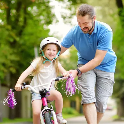 father-teaching-daughter-how-to-ride-a-bicycle
