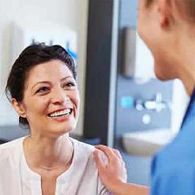 Male nurse speaking to female patient with dark hair