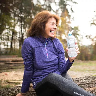 Middle-aged woman with plastic bottle in park
