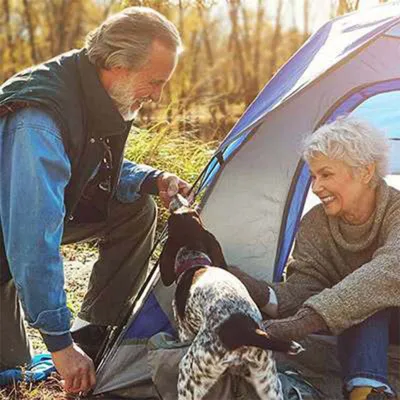Senior couple camping with dog