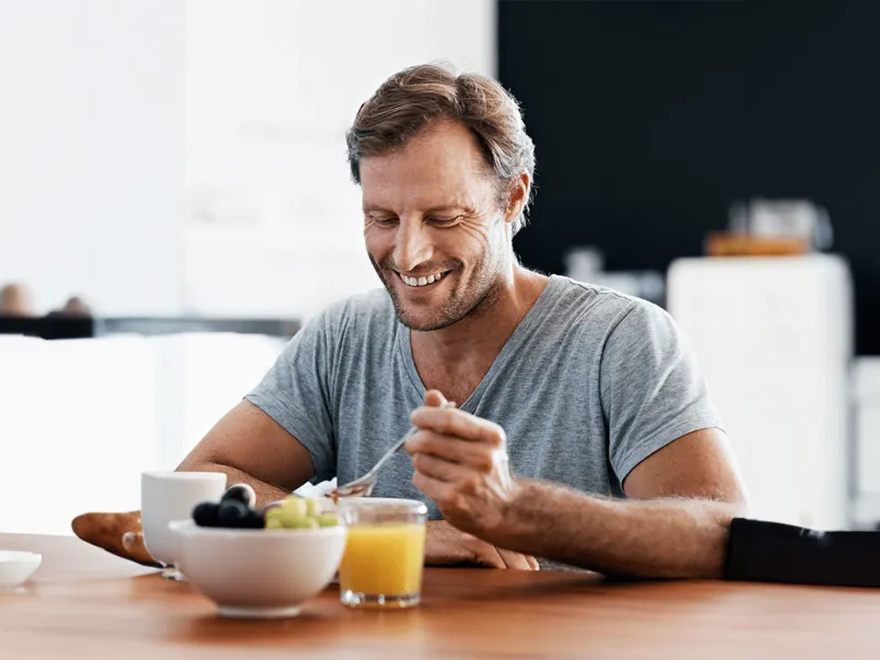 man-eating-and-smiling-indoors