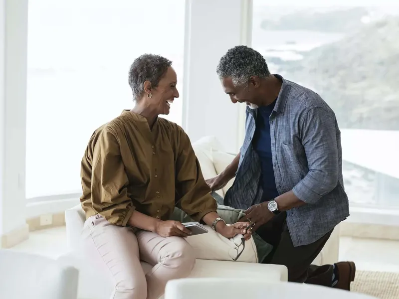 Older black couple laughing at home