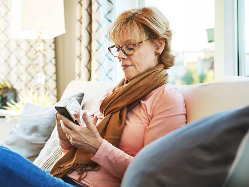 woman-seating-looking-at-her-mobile-phone