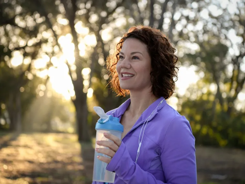 A woman outdoors taking a break from a run