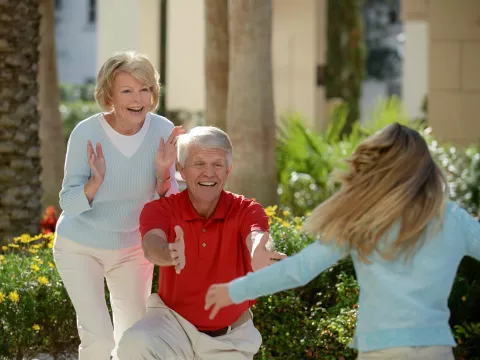 A girl sees her grandparents for the first time and runs to hug them.