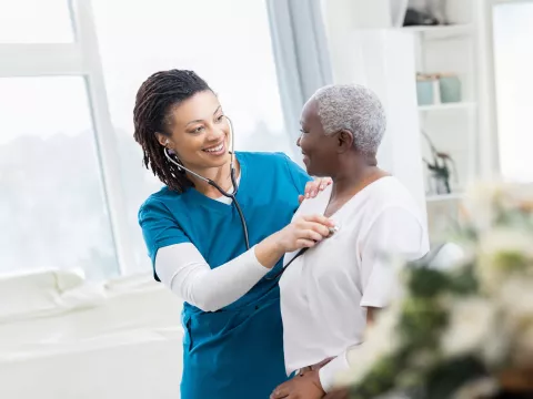 nurse-checking-her-patient-heart-while-both-smile