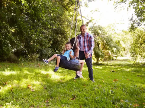 man-playing-with-his-children-outdoors