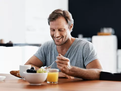 man-eating-and-smiling-indoors