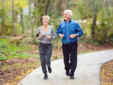 Older couple running in park