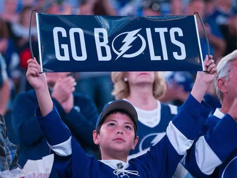 Boy in crowd with Go Bolts sign