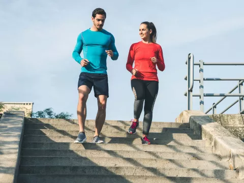 Young couple running down steps