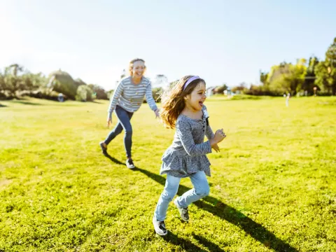 mother-and-daughter-running-and-laugjing-outdoors