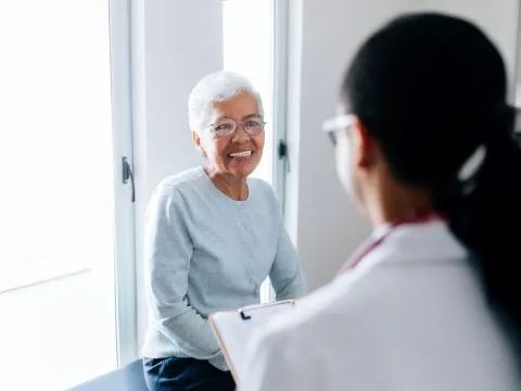 elderly woman talking to a doctor in a doctors office
