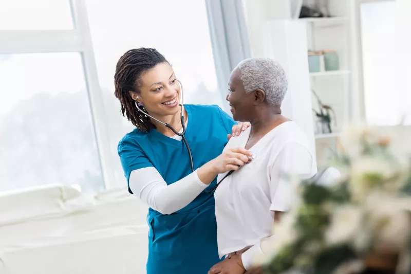 nurse-checking-her-patient-heart-while-both-smile