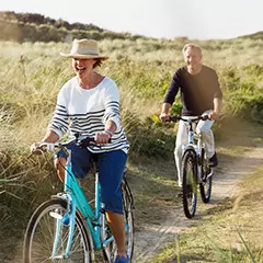 older couple riding bikes outside