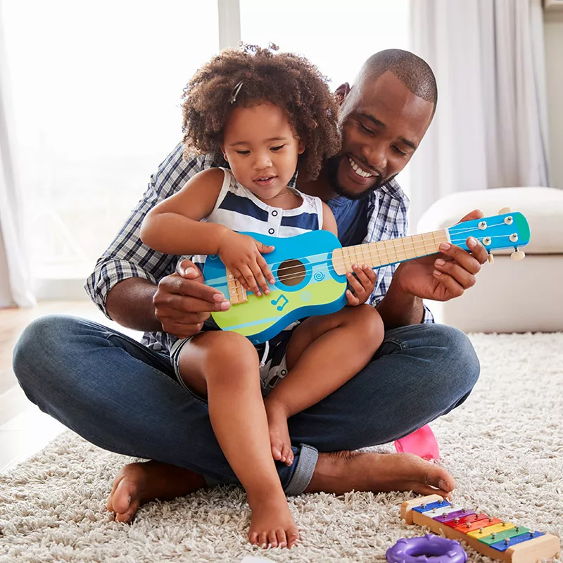 dad daughter playing toy guitar