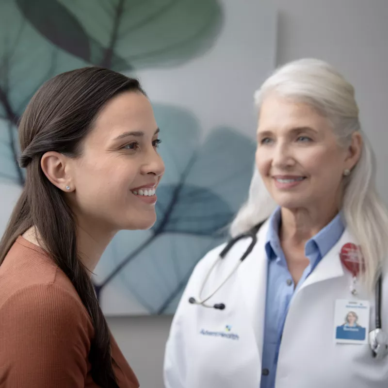 Young female patient with older female physician in an exam room.