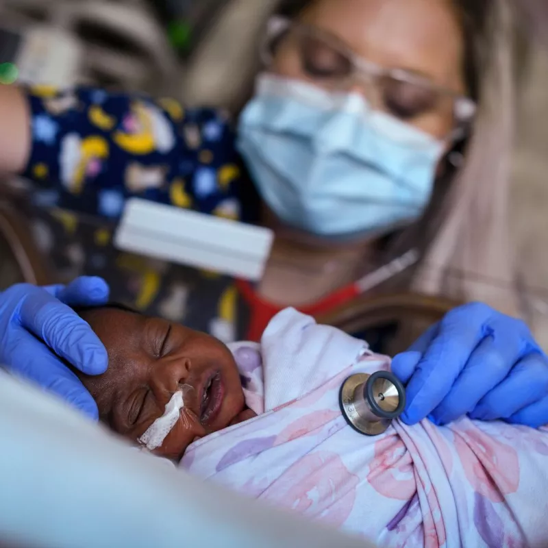 Nurse helping baby in nicu