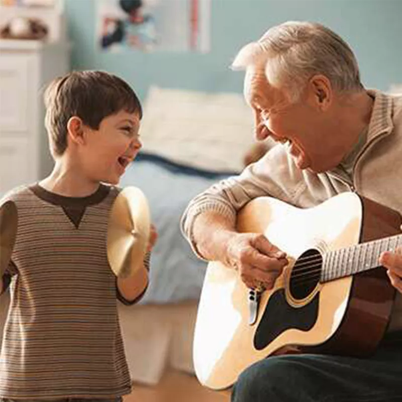 man playing guitar to a kid