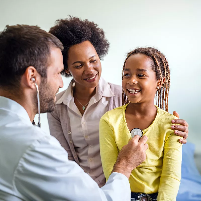 male doctor is checking girl patient heart