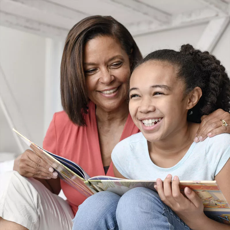 grandmother-and-grandaughter-read-a-book-and-laugh