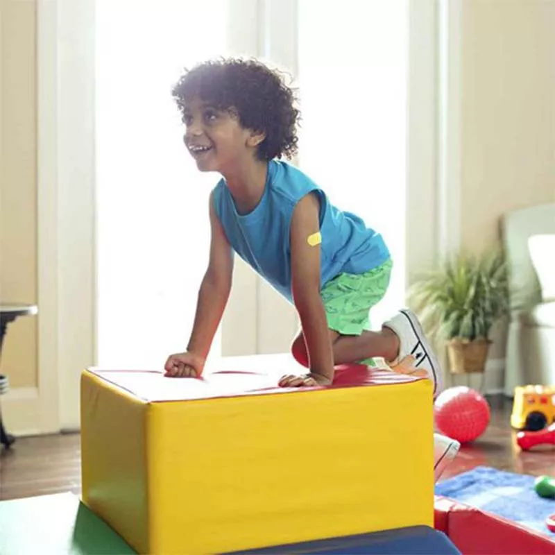 Boy climbing on soft blocks at home