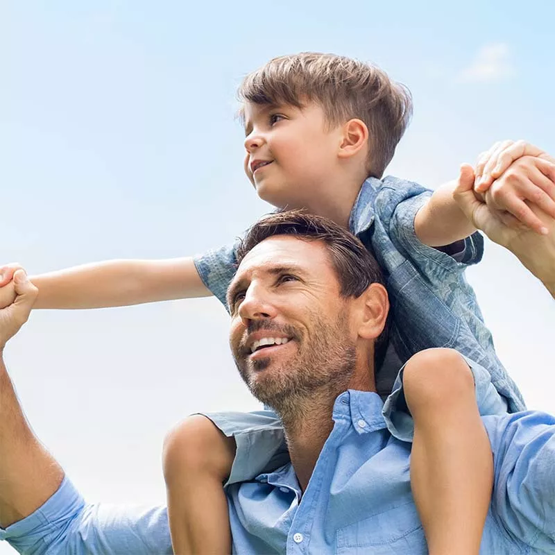 Boy riding on father's shoulders