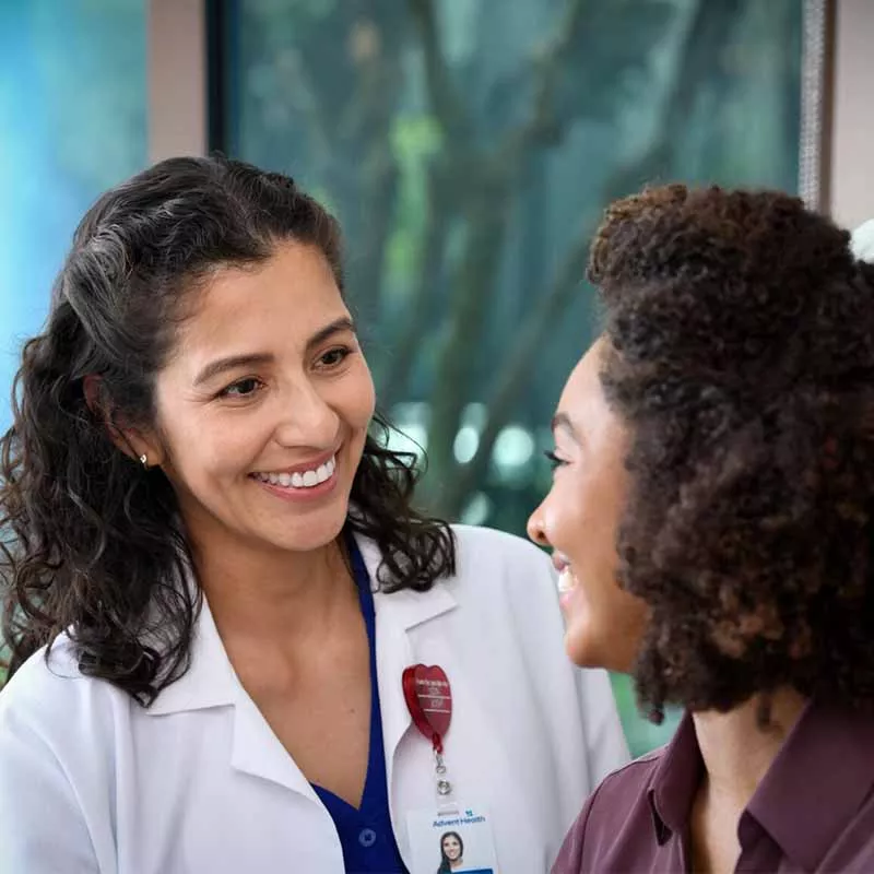 Female doctor smiling at young woman